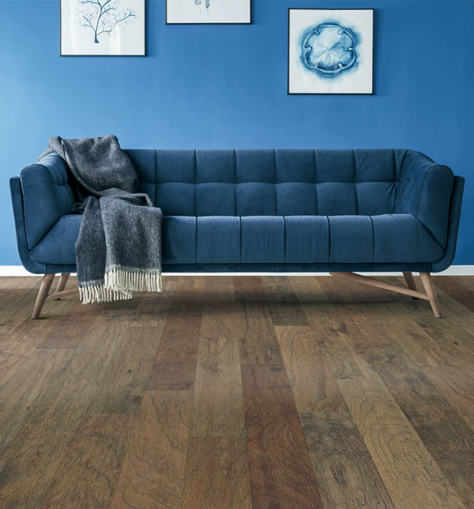 Nice blue couch on hardwood flooring | Bobs Discount Carpet Inc